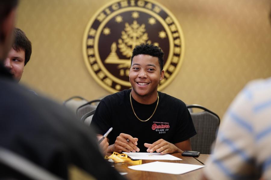 A student sitting at a table with other students.