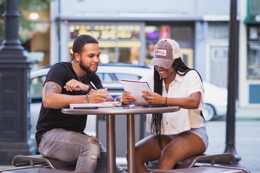 Two students looking at a notebook in downtown Kalamazoo.